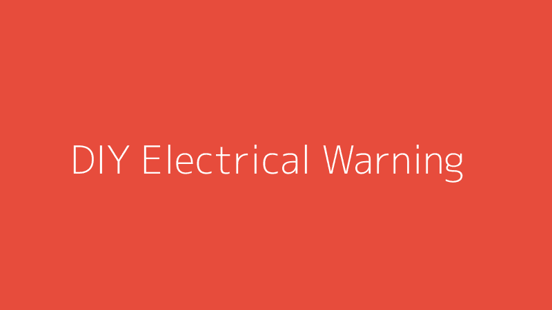 A warning sign over electrical tools, symbolizing the dangers of DIY electrical work.